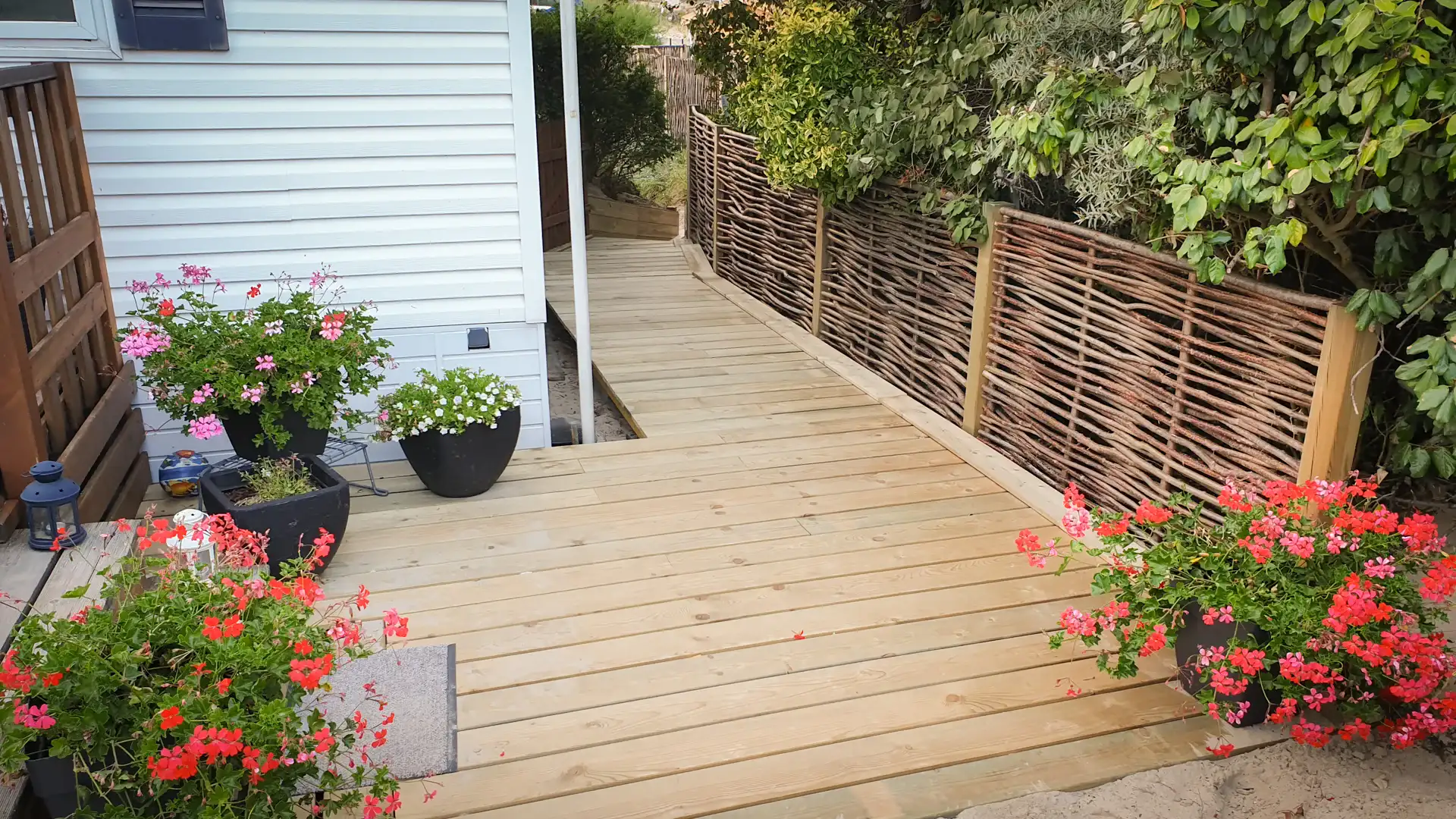 Terrasse en bois de sapin autoclave classe 4 avec clôture en bois de noisetier